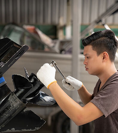 Marine Service Technician working on boat motor prop