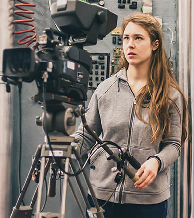 Camera woman looking into camera view finder