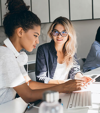 two women in an office looking at a computer