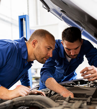 Master Automotive Service Technicians inspecting car engine