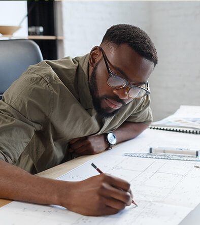 Drafting student working on building plans